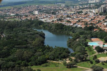 Imagem vista de cima da lagoa do taquaral, é possivel ver muitas arvores ao meio a lagoa e em volta muitas casas e predios.