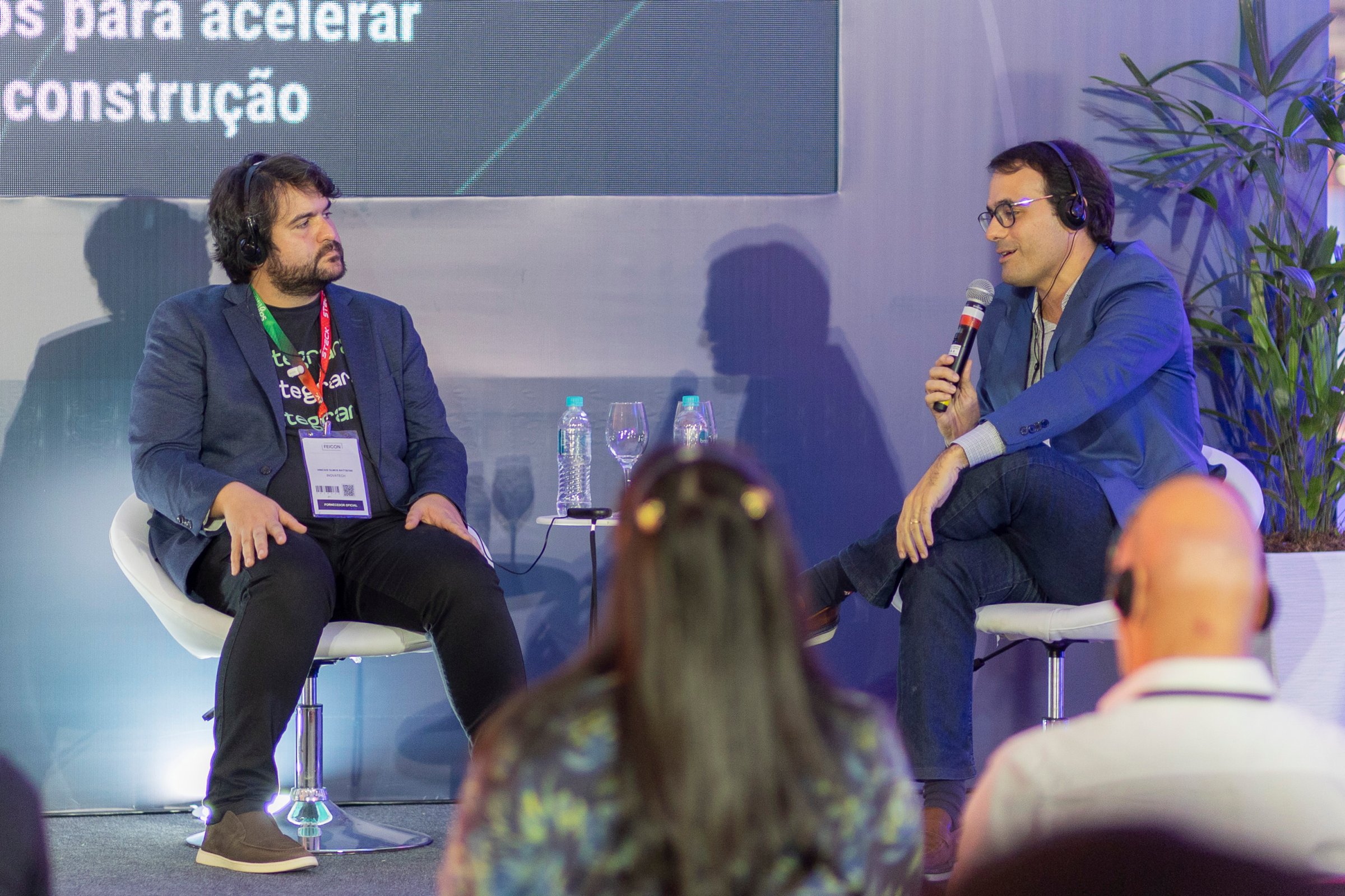 palestrantes no palco e um falando ao microfone