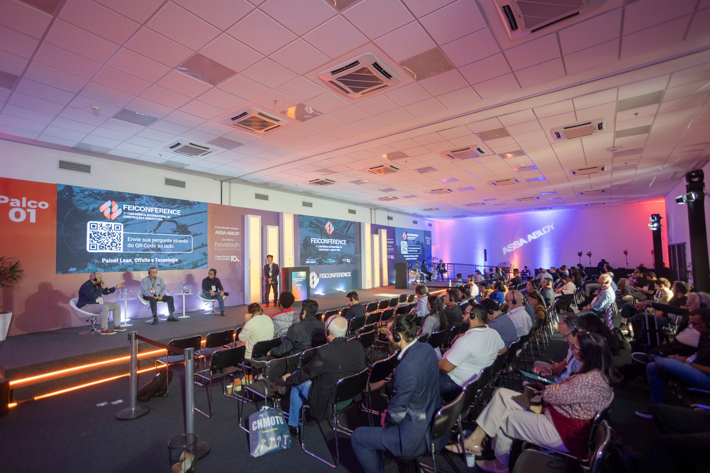palco com palestrantes e publico